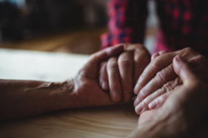 65488475 - close-up of senior couple holding hands at home